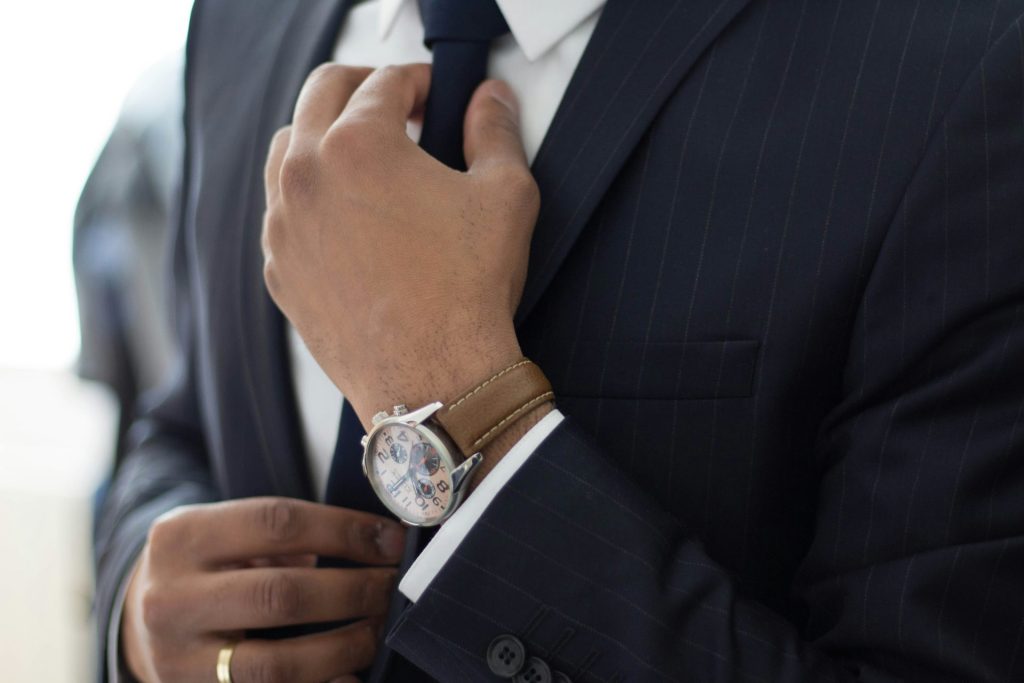 hombre vestido con reloj y traje negro